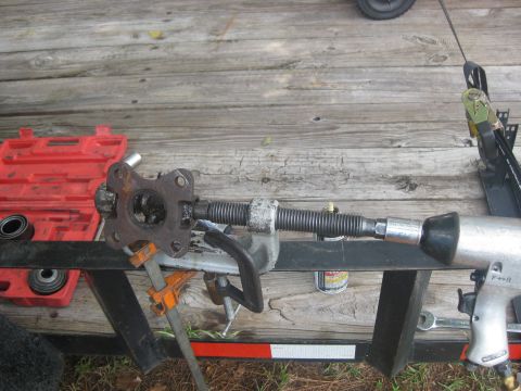 1994 Ford Bronco - A steering component is being worked on with a threaded rod and an impact wrench, with a red tool case nearby.