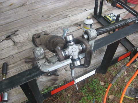 1994 Ford Bronco - A driveshaft universal joint is being worked on while clamped in a vise on a trailer.