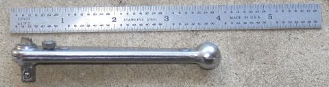 2000 Ford Crown Victoria - A close-up view of a metal ratchet wrench positioned next to a stainless steel ruler for scale.