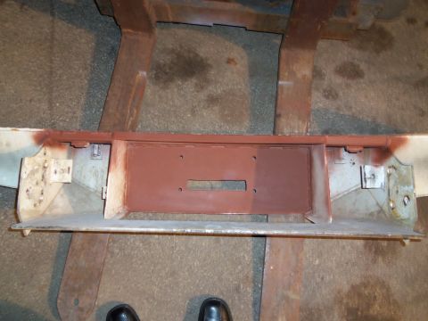 1989 Ford Bronco - A metal car component, possibly a bumper or frame section, is shown with primer applied.