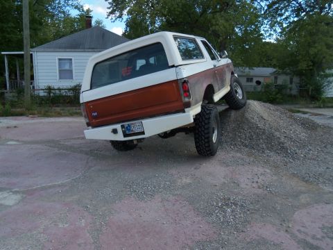 1989 Ford Bronco - This modified 1980s Ford Bronco is shown from the rear as it climbs a mound of gravel.