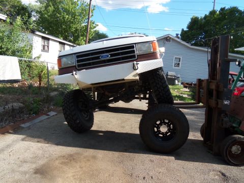 1989 Ford Bronco - This heavily modified Ford truck features a custom bumper and oversized tires, giving it a significantly lifted appearance.