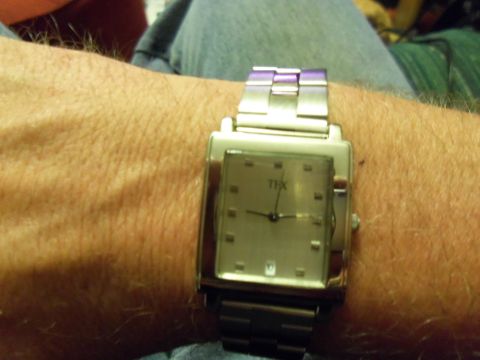 1989 Ford Bronco - A watch with a metal band is worn on a wrist. The watch face displays the text 'THX'.