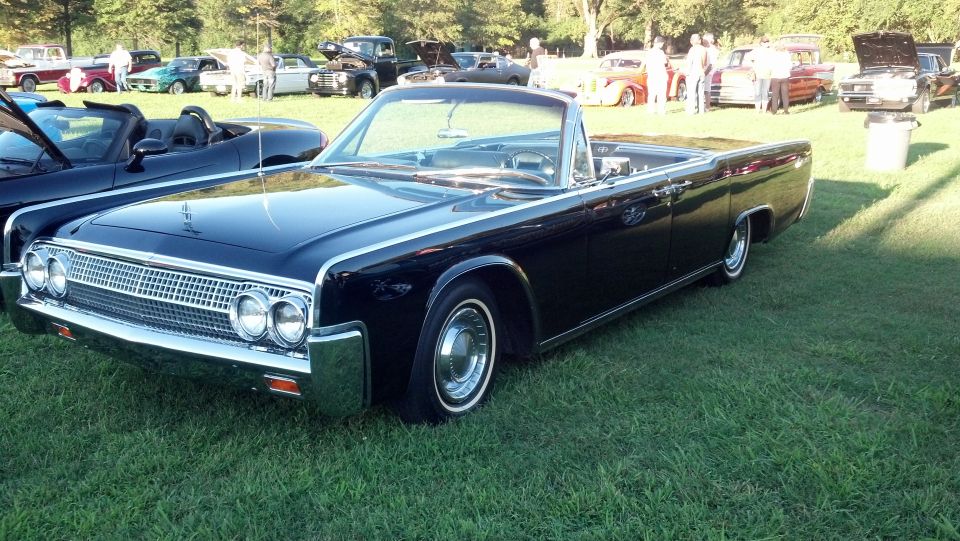 Black 1961 Lincoln Continental convertible parked on grass