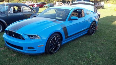 2007 Ford Mustang - Blue Ford Mustang Boss 302 with black stripes parked on grass at an outdoor car show.