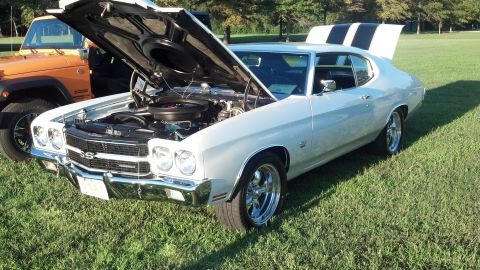 2007 Ford Mustang - White 1970 Chevrolet Chevelle SS at a car show, hood open, with an orange Jeep nearby.