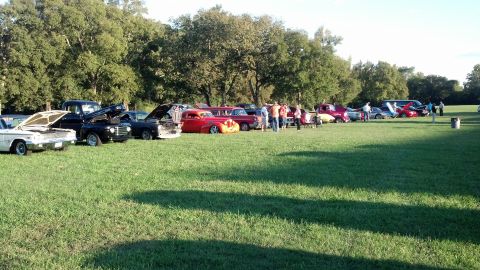 2007 Ford Mustang - A collection of vintage automobiles are displayed on a lawn during an outdoor event.