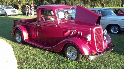 2007 Ford Mustang - A classic maroon pickup truck is displayed with its hood open at an outdoor car show.