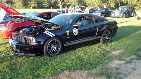 2007 Ford Mustang - A black 2007 Ford Mustang Shelby GT500 is displayed at an outdoor car show with its hood open.