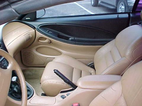 1995 Ford Mustang - Interior view of a car, showing tan leather seats and the dashboard area.