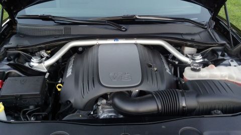 2007 Ford Mustang - The V8 engine of a Dodge Challenger is visible under the hood, a Mopar strut tower brace.