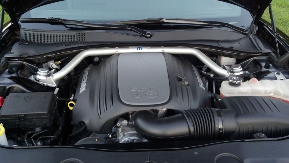 Engine bay of a Dodge Challenger with a V8 engine and a Mopar strut tower brace
