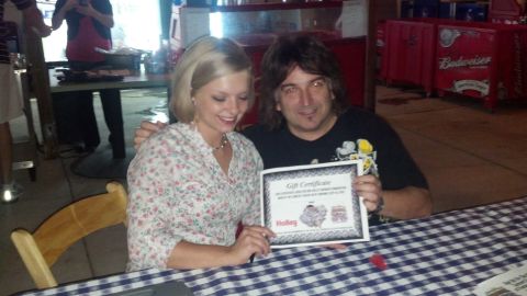 2007 Ford Mustang - Snapshot of two people holding a printed gift certificate, not a technical document.