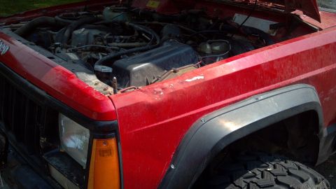 1995 Jeep Cherokee - Front view of a red 1995 Jeep Cherokee showing the engine compartment.