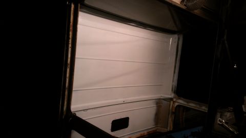 1978 Ford Bronco - The interior of a vehicle shows white paneled walls and a dark, empty space.