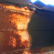 1978 Ford Bronco - Detail of extensive rust damage on a metal surface, showing signs of decay.