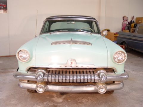 1954 Mercury Monterey - A light blue 1954 Mercury Monterey with a black roof is parked indoors, with another vehicle visible in the background.