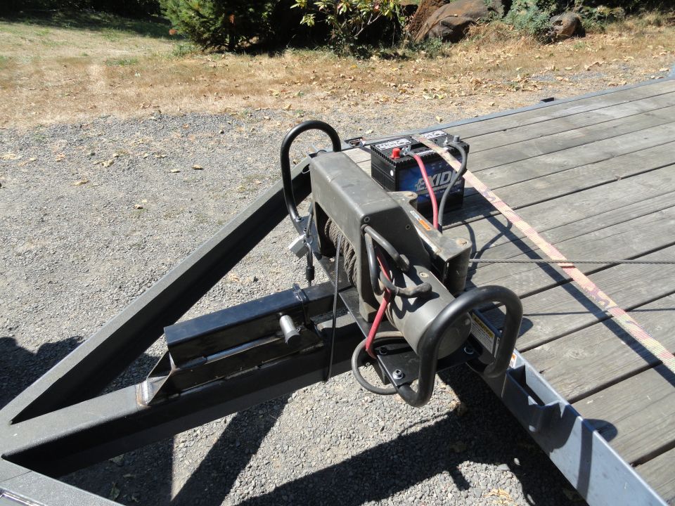 Winch and Exide battery on a wooden trailer deck, with metal frame