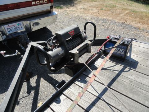 1966 International Scout 800 - A winch and battery are mounted on a trailer being towed by a Ford truck.