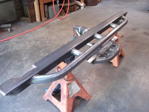 1989 Ford Bronco - Custom metal slider step with integrated grab handles, shown mounted on orange jack stands in a workshop.