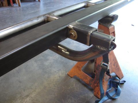 1989 Ford Bronco - Metal slider bar assembly supported by jack stands, likely for a vehicle modification.