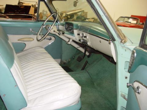 1954 Mercury Monterey - The interior of a classic car, a two-tone seat and dashboard, with another car visible in the background.