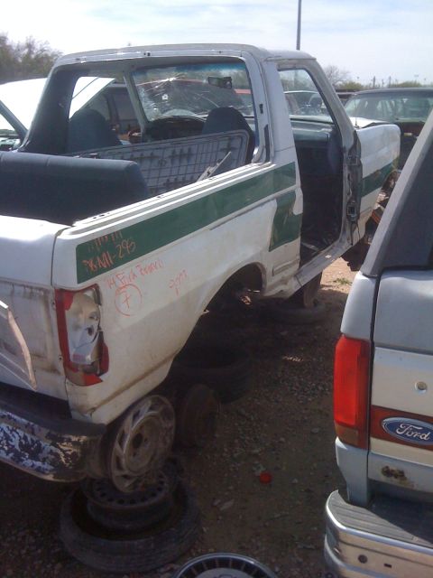 1979 Ford Bronco - Junkyard pickup truck, likely stripped for parts. The vehicle is heavily damaged and missing many components.
