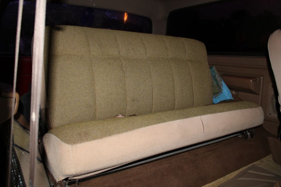 1990 Ford Bronco rear bench seat with patterned green fabric and beige lower cushion