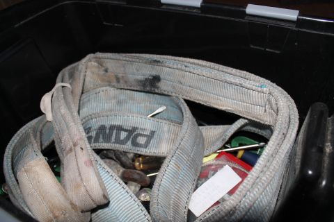 1990 Ford Bronco - Tow strap and tools stored in a toolbox. The strap has 'PAN' printed on it.