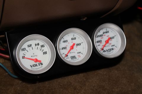1990 Ford Bronco - Interior view of a vehicle's dashboard showing three aftermarket gauges for voltage, oil pressure, and water temperature.
