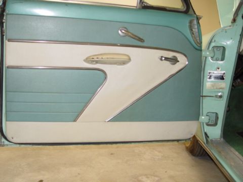 1954 Mercury Monterey - The interior door panel of a 1954 Mercury Monterey features a distinctive two-tone design with light cream and teal upholstery, accented by…