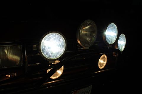 1990 Ford Bronco - Several auxiliary lights are mounted to the front of a vehicle, illuminating the darkness.