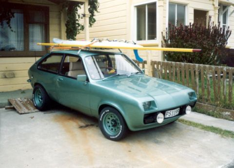 1969 Lincoln Continental - This green hatchback is equipped with a roof rack carrying two surfboards and a yellow paddle.