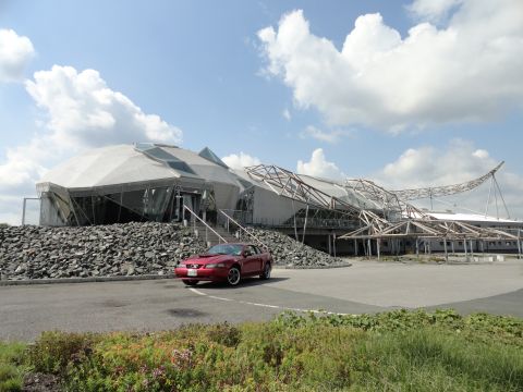 2003 Mercury Marauder - A red coupe is parked in front of a unique, modern building with a geodesic dome and exposed metal framework.