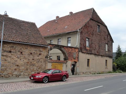 2003 Mercury Marauder - A red Ford Mustang is parked on a cobblestone street next to historic European-style buildings.