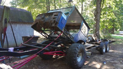 1978 Ford Bronco - Disassembled vehicle chassis being worked on, loaded onto a trailer outdoors.