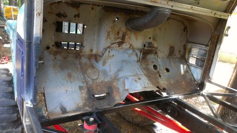 1978 Ford Bronco - The interior of a heavily rusted vehicle shows a damaged firewall and exposed metal framework.