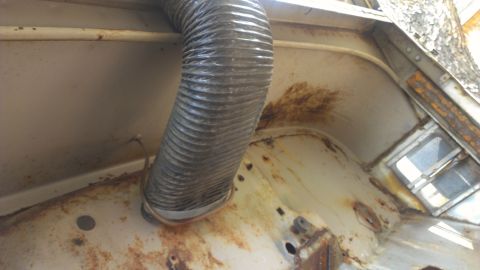 1978 Ford Bronco - Interior view of a heavily rusted vehicle, showing flexible ducting and signs of wear.