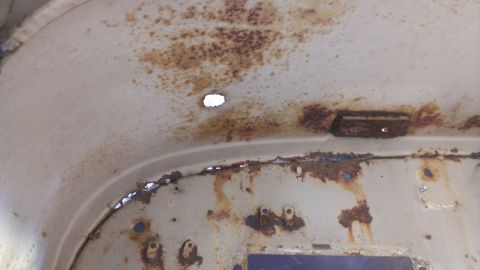 1978 Ford Bronco - Interior metal panel shows significant rust damage and a small hole.