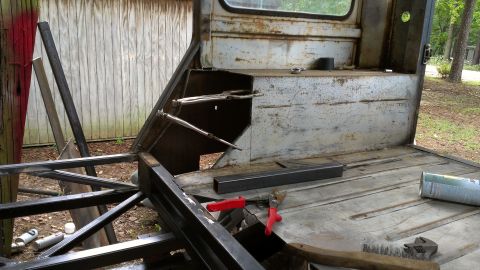 1978 Ford Bronco - The interior of a vehicle is shown during a construction or restoration process, with various metal parts and tools visible.