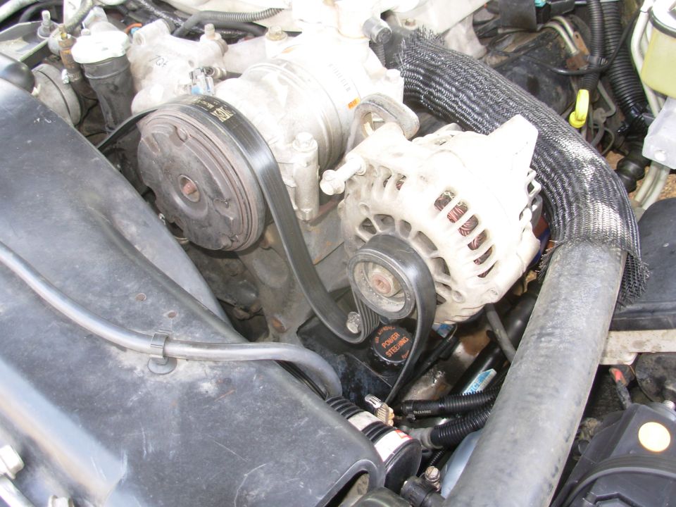 Engine bay accessory drive showing alternator, A/C compressor and serpentine belt