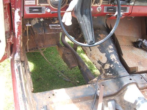 1966 Ford Ranchero - The interior of a vehicle shows significant rust and damage, indicating it is under construction.