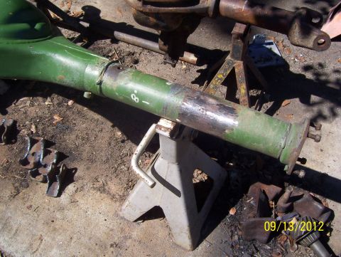 1990 Ford Bronco - A green painted axle housing is shown supported by jack stands, with other parts visible in the background.