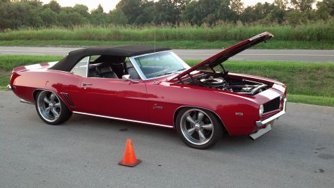 2007 Ford Mustang - This red 1969 Chevrolet Camaro convertible features custom wheels and its hood is open, revealing the engine.