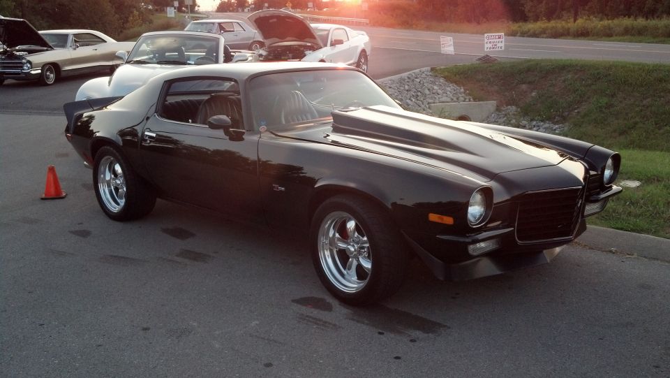 Black 1970s Chevrolet Camaro with cowl hood and chrome wheels