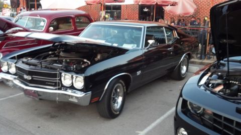 2007 Ford Mustang - A black 1970 Chevrolet Chevelle SS is displayed with its hood open, alongside other vehicles at an outdoor event.
