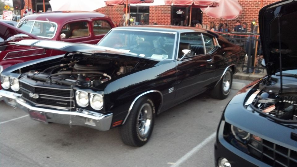 Black 1970 Chevelle SS parked next to a red classic car and a modern Camaro