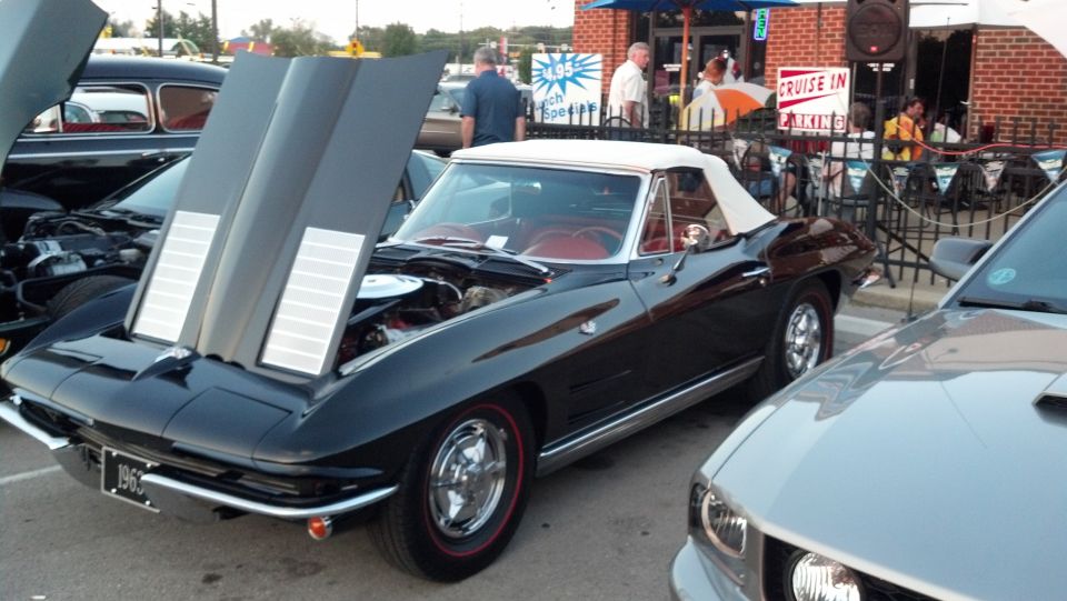 Black 1966 convertible Corvette with hood open, red interior