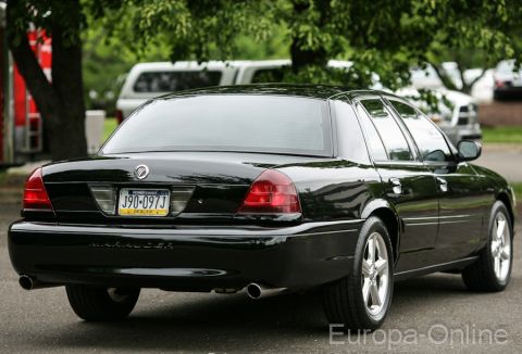 2003 Mercury Marauder - Rear view of a black 2003 Mercury Marauder sedan parked outdoors with trees and other vehicles in the background.