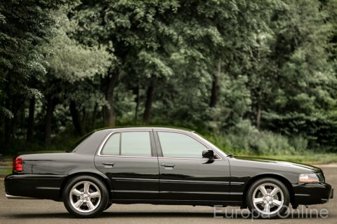 2003 Mercury Marauder - Side profile of a black 2003 Mercury Marauder sedan parked outdoors with trees in the background.